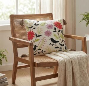 Hand-embroidered floral cushion cover by TheLitLoom featuring blue and earthy toned flowers on premium white cotton fabric with corner tassels.
